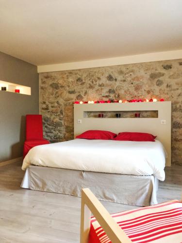a bedroom with a large bed and a red chair at Chambre d'hôtes La Font in Eygliers