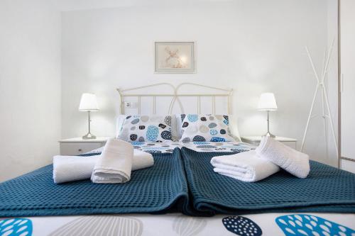 a bedroom with a bed with blue and white pillows at Mar de Lava Sunrise Fuerteventura in Pozo Negro