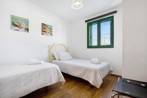 a bedroom with two beds and a window at Mar de Lava Sunrise Fuerteventura in Pozo Negro