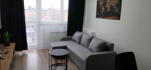 a living room with a couch and a table at APARTAMENT Klasztorna Centrum Nowy Sącz in Nowy Sącz