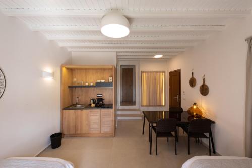 a kitchen and dining room with a table and chairs at Edem Garden Residence by Estia in Platis Yialos Mykonos