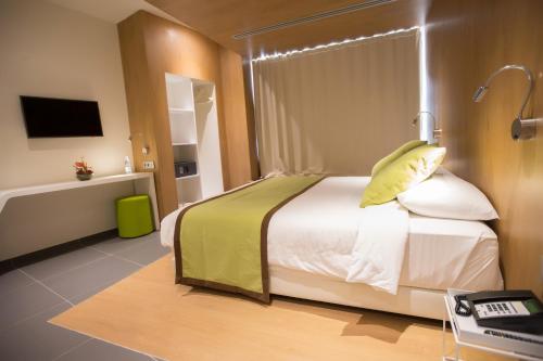 a hotel room with a bed and a television at Seen Hotel Abidjan Plateau in Abidjan