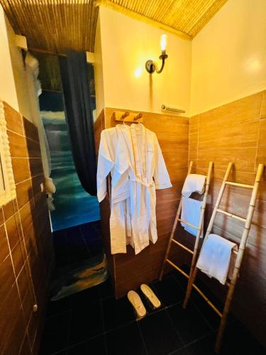 a bathroom with a shower with a white shirt on a rack at Maison du Bonheur in Dakar