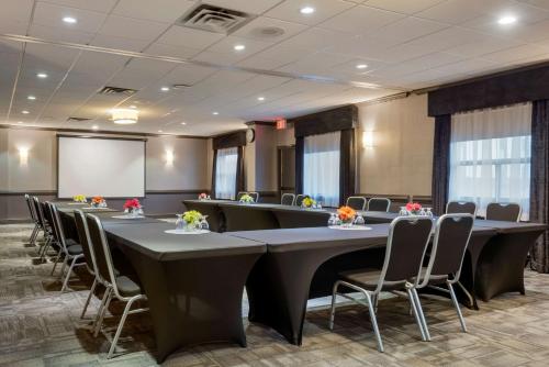 a conference room with tables and chairs and a screen at Best Western Plus Village Park Inn in Calgary