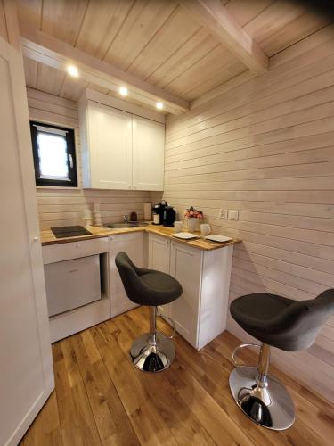 a small kitchen with two stools in a room at Apartamenty EverySky - Domek Koło Karpacza in Mysłakowice
