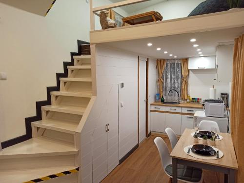 a kitchen and dining room with a staircase in a tiny house at Tiny House in Narva-Jõesuu