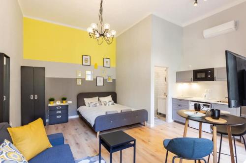 Cet appartement comprend une chambre avec un lit et une table ainsi qu'une cuisine. dans l'établissement A27- Boutique Apartments, Best Location. By BQA, à Budapest