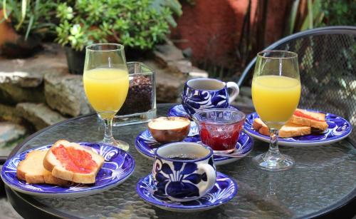 ein Tisch mit Tellern mit Toast und zwei Gläsern Orangensaft in der Unterkunft Hotel La Posada del Angel in San Salvador