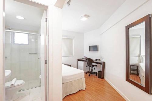 a white room with a bed and a sink and a desk at Tri Hotel Balneario Camboriu in Balneário Camboriú