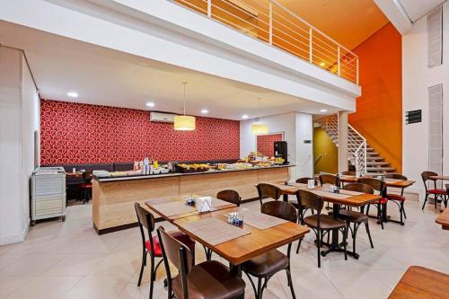 a restaurant with tables and chairs and a kitchen at Tri Hotel Balneario Camboriu in Balneário Camboriú