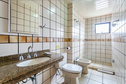 a bathroom with a sink and a toilet at Paraíso Palace Hotel II e III in Florianópolis