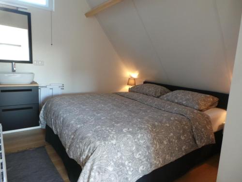 een slaapkamer met een bed, een wastafel en een raam bij Top appartement Short Stay in mooie omgeving Kortenhoef. in Kortenhoef