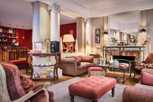 a living room filled with furniture and a fireplace at Hôtel Sainte-Beuve in Paris