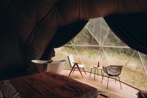 a bedroom with a bed and a large window at Mandra Hills in Richka