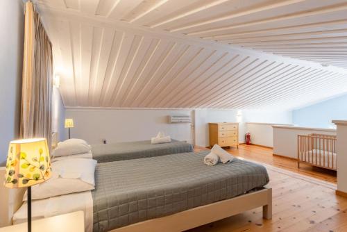 a bedroom with two beds and a white ceiling at Antigoni Beach House in Kounopetra