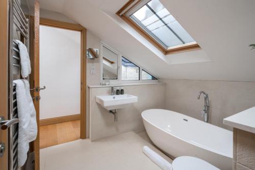 a bathroom with a white tub and a sink at ALTIDO Elegant house near Regent's Park in London