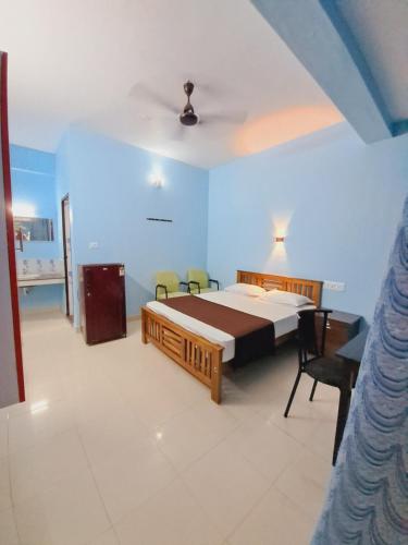 a bedroom with a bed and a table and chairs at Anamika Holiday home in Trivandrum