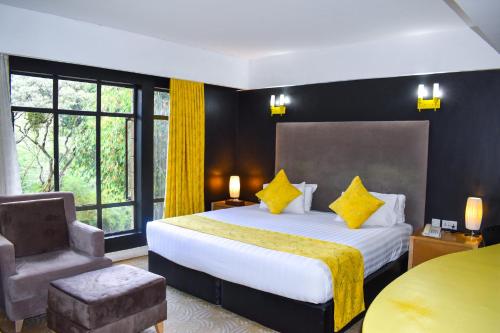 Habitación de hotel con cama y silla en West Wood Hotel, en Nairobi
