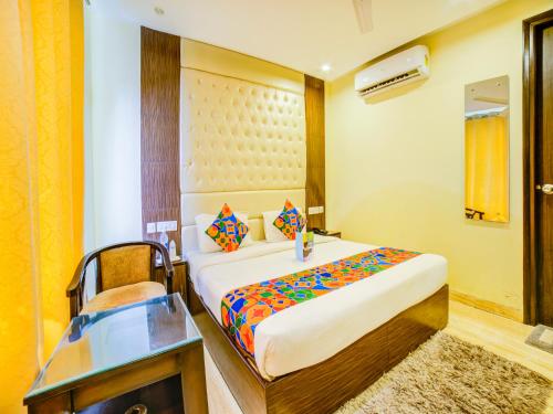 a bedroom with a bed and a desk in a room at FabHotel Diamond Zirakpur in Zirakpur