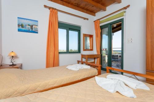 フランゴカステッロにあるSpiros Beach Villaのベッドルーム1室(ベッド2台、大きな窓付)