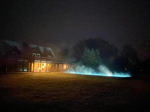 a house with lights in a field at night at NaturApartments - Hideaway & Spa in Burg