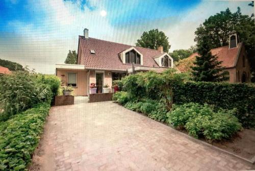 une maison avec une allée en briques devant elle dans l'établissement HOLTINGERHUYS Uffelte- Giethoorn! Optie Wellness!!!, à Uffelte