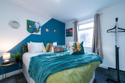 a bedroom with a bed with a blue wall at Jesouth Homey 5 Bedrooms 9 Beds - Contractors - Leisure - Central Location in Hull
