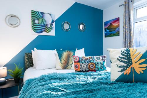 a bedroom with blue walls and a bed with a blue blanket at Jesouth Homey 5 Bedrooms 9 Beds - Contractors - Leisure - Central Location in Hull