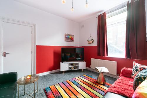 a living room with red walls and a flat screen tv at Jesouth Homey 5 Bedrooms 9 Beds - Contractors - Leisure - Central Location in Hull