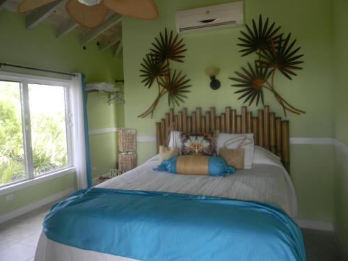 1 dormitorio con 1 cama grande en una habitación con paredes verdes en Harbor Breeze Villas en Clarence Town