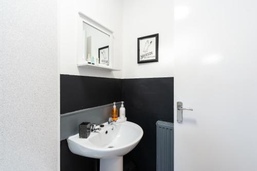 ein Badezimmer mit einem weißen Waschbecken und einem Spiegel in der Unterkunft Jesouth Homey 5 Bedrooms 9 Beds - Contractors - Leisure - Central Location in Hull