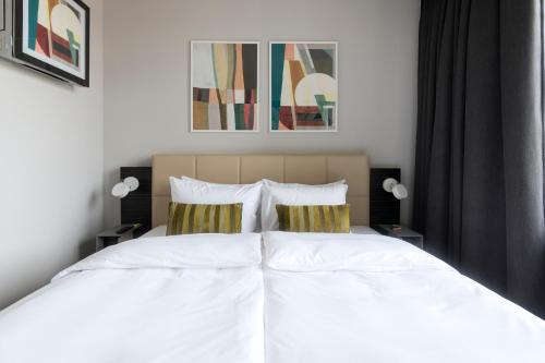 - une chambre avec 2 lits et des draps blancs dans l'établissement numa I Poise Rooms & Apartments, à Prague