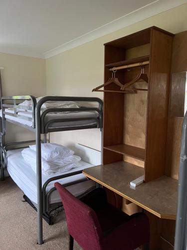 a dorm room with a desk and bunk beds at Saucy Mary's Hostel in Kyleakin