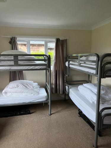 a room with three bunk beds and a window at Saucy Mary's Hostel in Kyleakin
