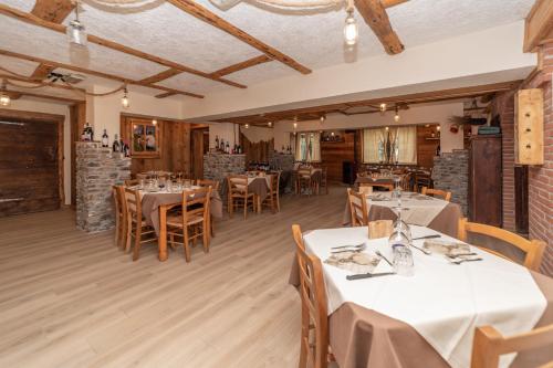 a dining room with white tables and chairs at Hotel Martin in Sauze dʼOulx