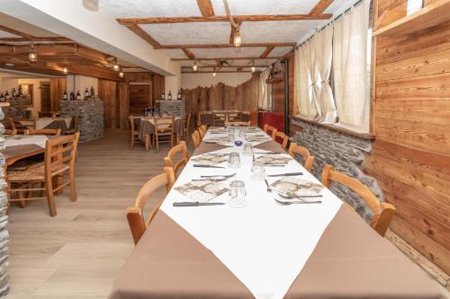 a dining room with a long table and chairs at Hotel Martin in Sauze dʼOulx