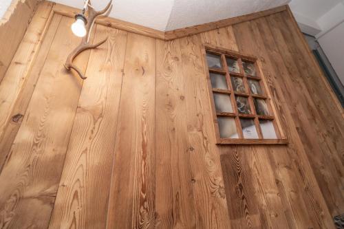 a wooden door with a window in a room at Hotel Martin in Sauze dʼOulx