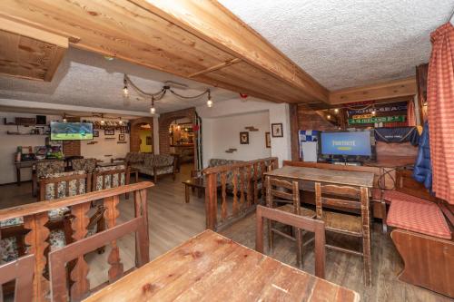 a dining room with wooden tables and chairs at Hotel Martin in Sauze dʼOulx