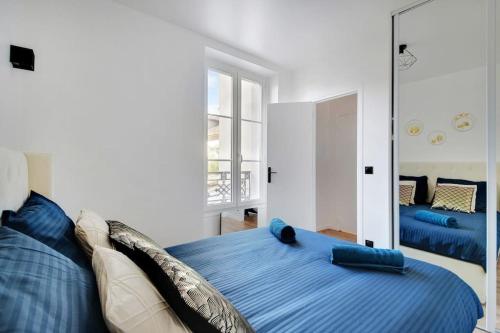 a bedroom with a blue bed and a mirror at Appartement 4 personnes aux Portes de Paris in Saint-Denis