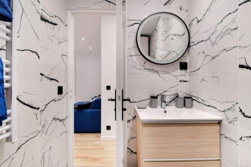 a bathroom with a sink and a mirror at Appartement 4 personnes aux Portes de Paris in Saint-Denis