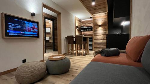 a living room with a couch and a flat screen tv at Les Cerfs - Appartement & Studio - ANZERE in Anzère