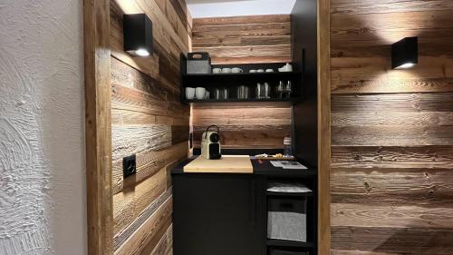 a kitchen with wooden walls and a counter with a sink at Les Cerfs - Appartement & Studio - ANZERE in Anzère