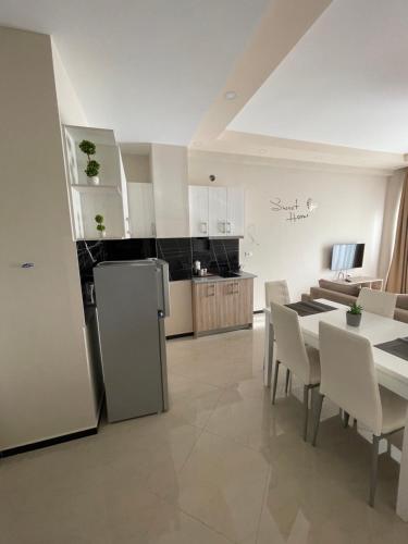 een keuken en woonkamer met een tafel en stoelen bij Seaside Apartmens Sarande in Sarandë