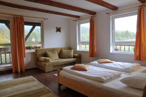a bedroom with two beds and a couch and windows at Complex Pastravaria Albota in Arpaşu de Sus