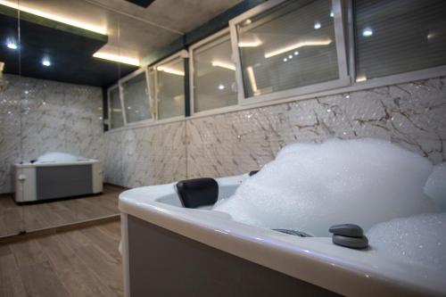 a bathroom with a bath tub filled with foam at Monogramlux in Inđija