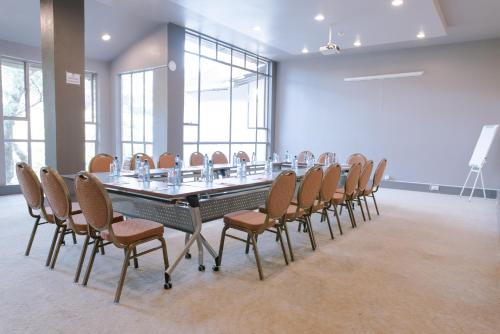 a conference room with a long table and chairs at West Wood Hotel in Nairobi