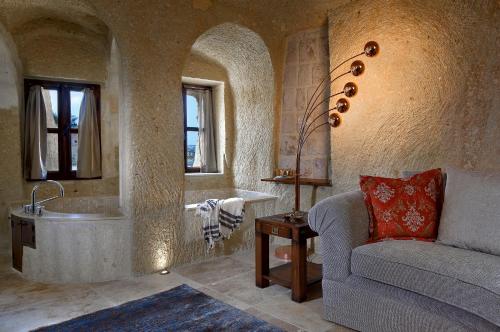 a bathroom with a couch and a sink and a tub at Seraphim Cave Suites & SPA in Urgup
