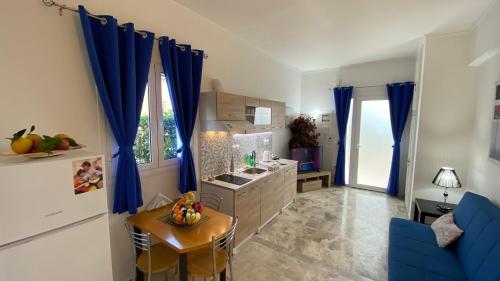 a kitchen with blue drapes and a table and a blue couch at Patras Blue Suite in Patra