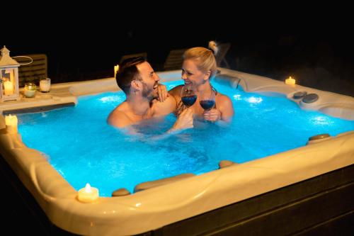 a man and woman drinking wine in a hot tub at House "Dare to dream" in Vrdnik