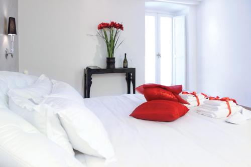 a white bed with two red pillows on it at Hub Navona in Rome
